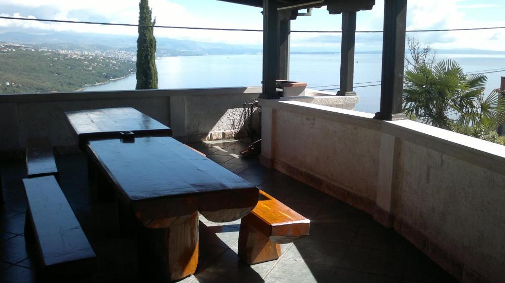 two benches on a balcony with a view of the water at Apartments Opatija Sea View in Opatija