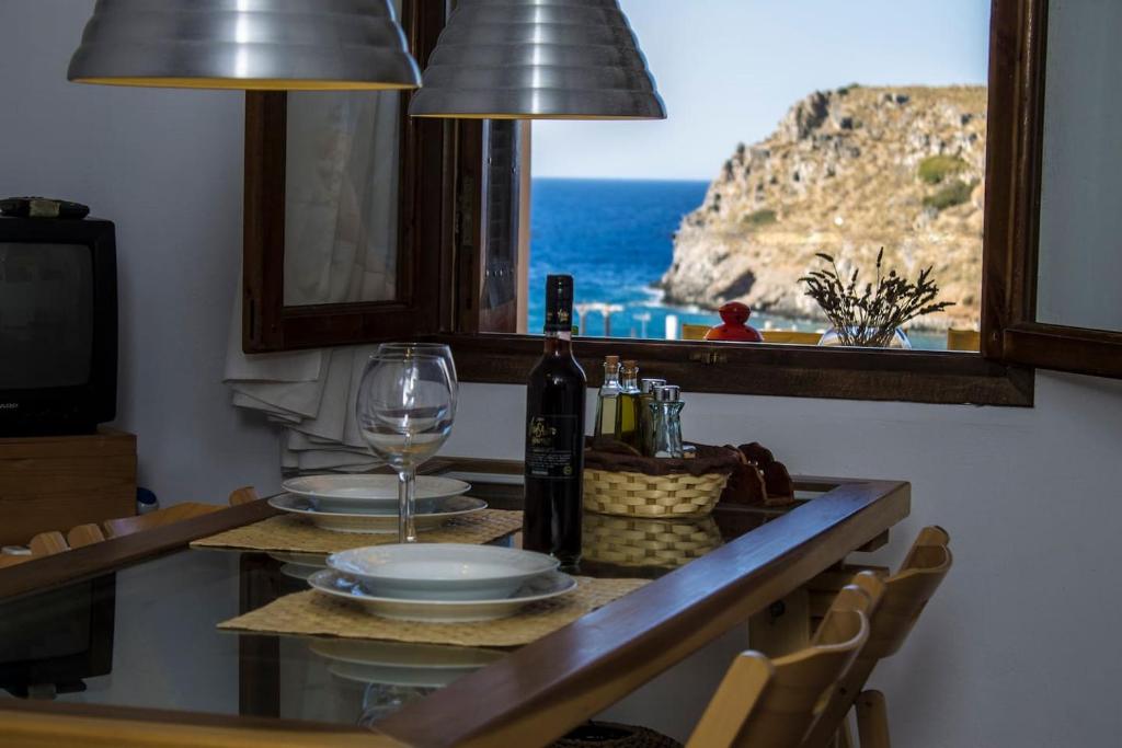 a table with a wine glass and a view of the ocean at Mohlos house with Seaview in Mochlos