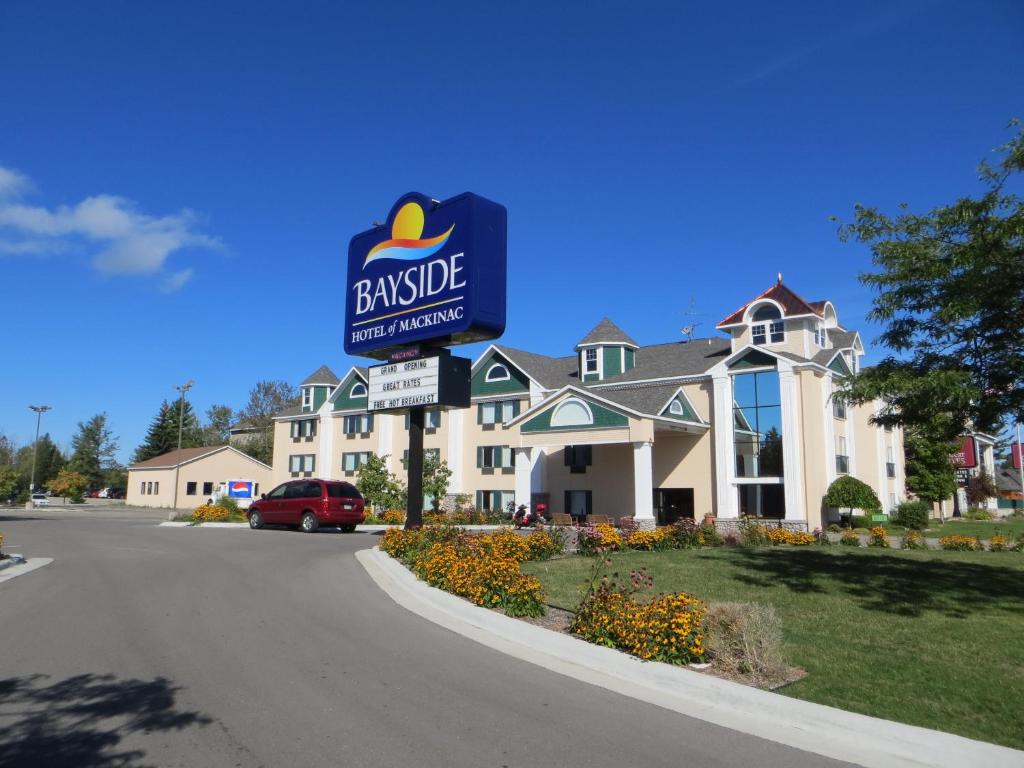 a large building with a sign for a house at Bayside Hotel of Mackinac in Mackinaw City