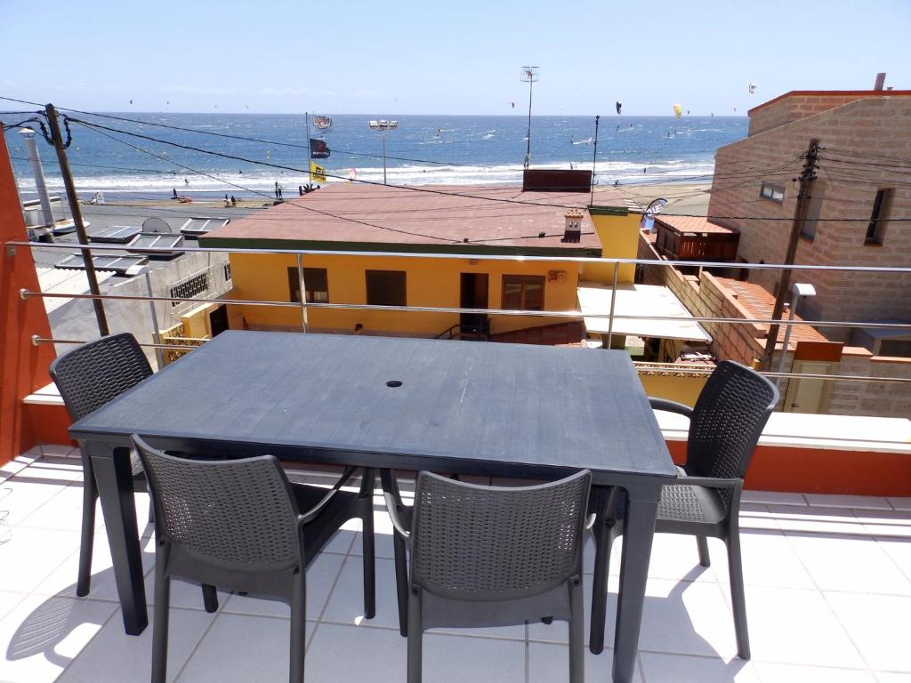 einen Tisch und Stühle auf einem Balkon mit Meerblick in der Unterkunft Apartamentos Medano - Duplex Sea Views in El Médano