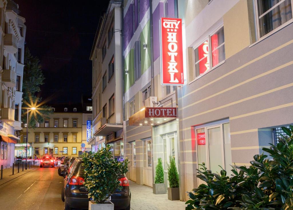 un edificio con un cartello hotel sul lato di una strada di City Hotel Wiesbaden a Wiesbaden