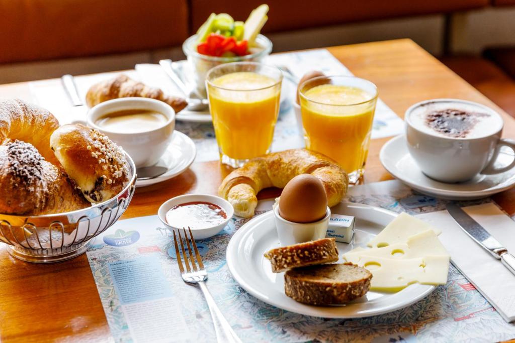 a table with a breakfast of eggs and bread and drinks at Hauser Hotel St. Moritz in St. Moritz