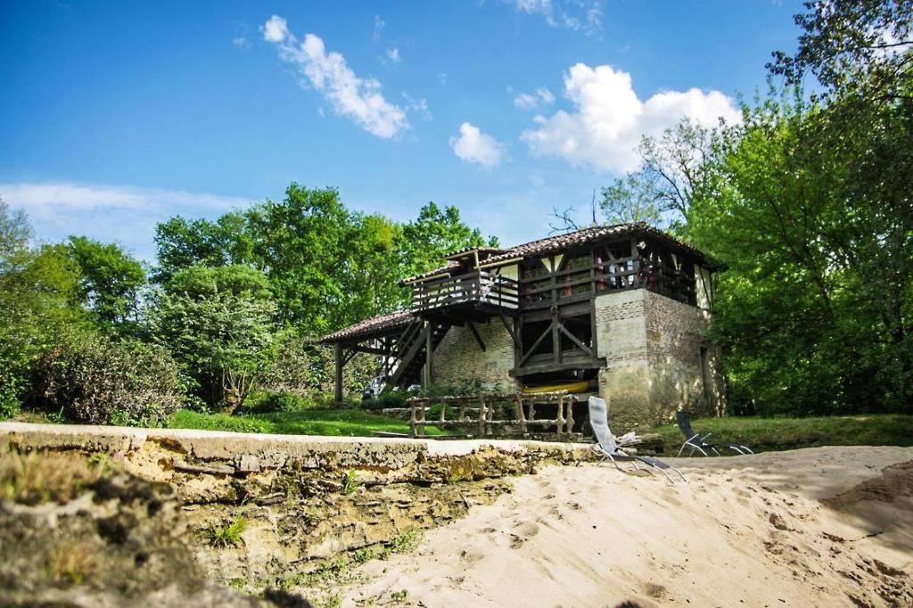 a building in the middle of a field with trees at Moulin de Saint Cricq in Saint-Cricq-Villeneuve