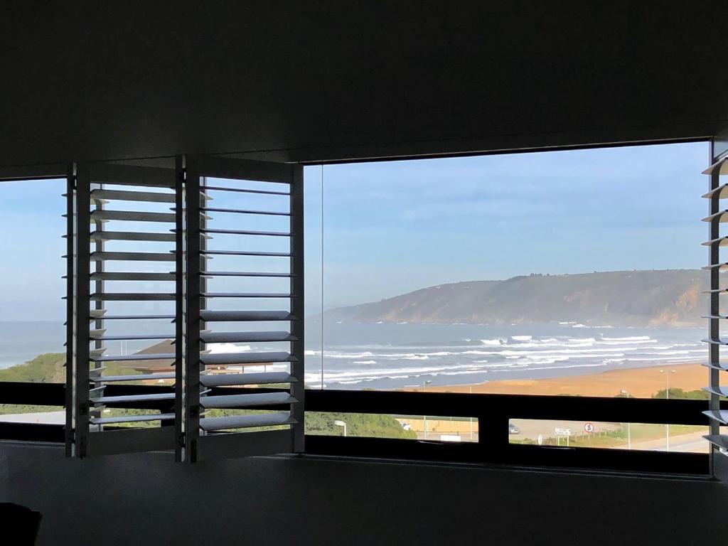 a room with a large window with a view of the ocean at Villa Sol in Wilderness