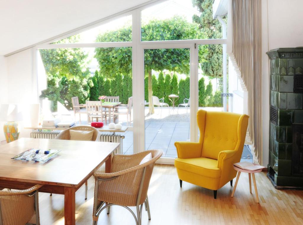 a dining room with a table and a yellow chair at Ferienhaus Sunny in Gengenbach