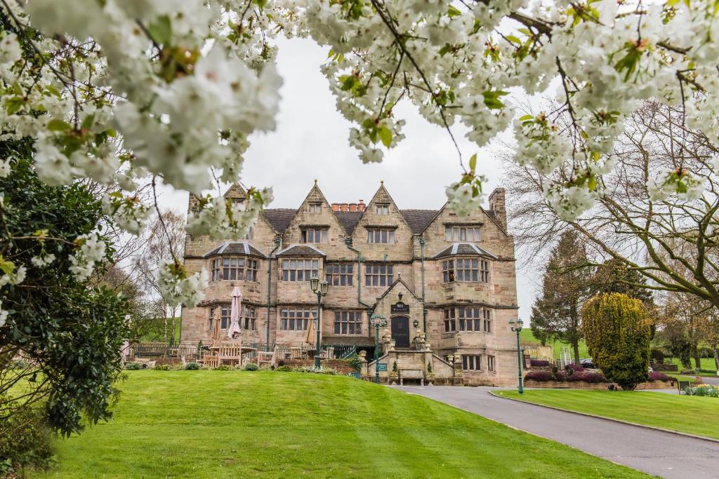 een oud kasteel met witte bloemen ervoor bij Weston Hall in Stafford