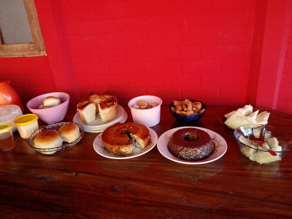 una mesa cubierta con platos de bollería y tazones de comida en Pousada Bergehaus en Domingos Martins