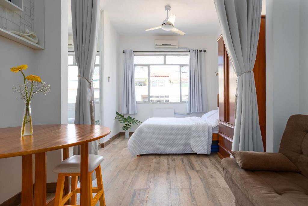 a living room with a bed and a table at Apartamento Copacabana RJ in Rio de Janeiro