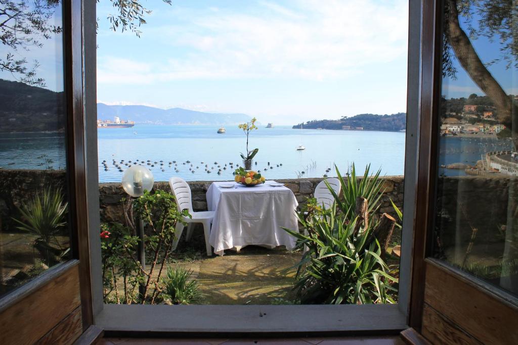 un tavolo con vista sull'acqua da una finestra di B&B La Palafitta a Portovenere