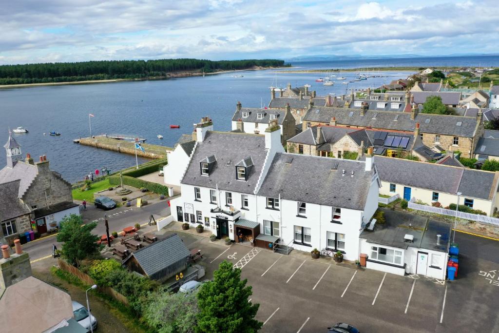 a small town with houses and boats on the water at Crown and Anchor Inn in Findhorn