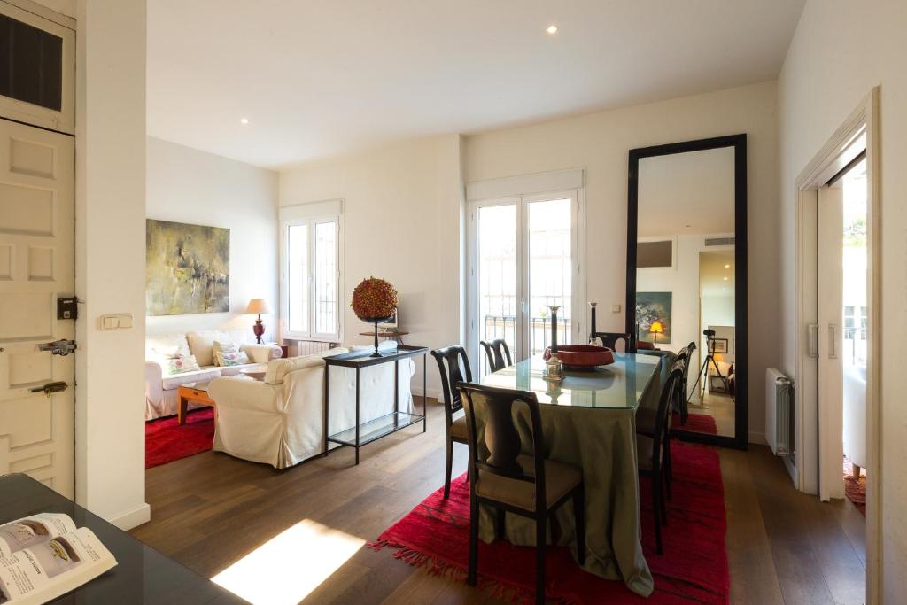 a dining room and living room with a table and chairs at Veoapartment Mateos Gago 2D in Seville