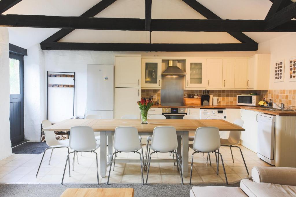 a kitchen and dining room with a table and chairs at Goonwinnow Farm Cottages in Newquay