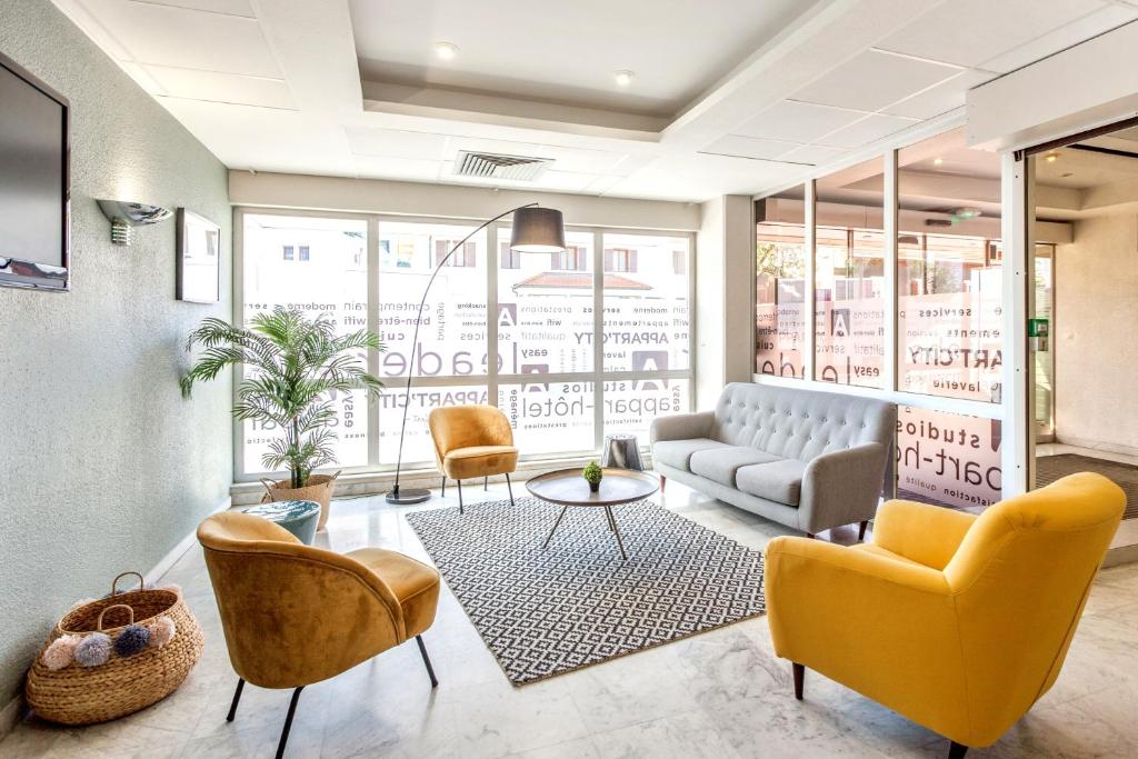 a lobby with a couch and chairs and a table at Appart'City Classic Genève - Gaillard in Gaillard