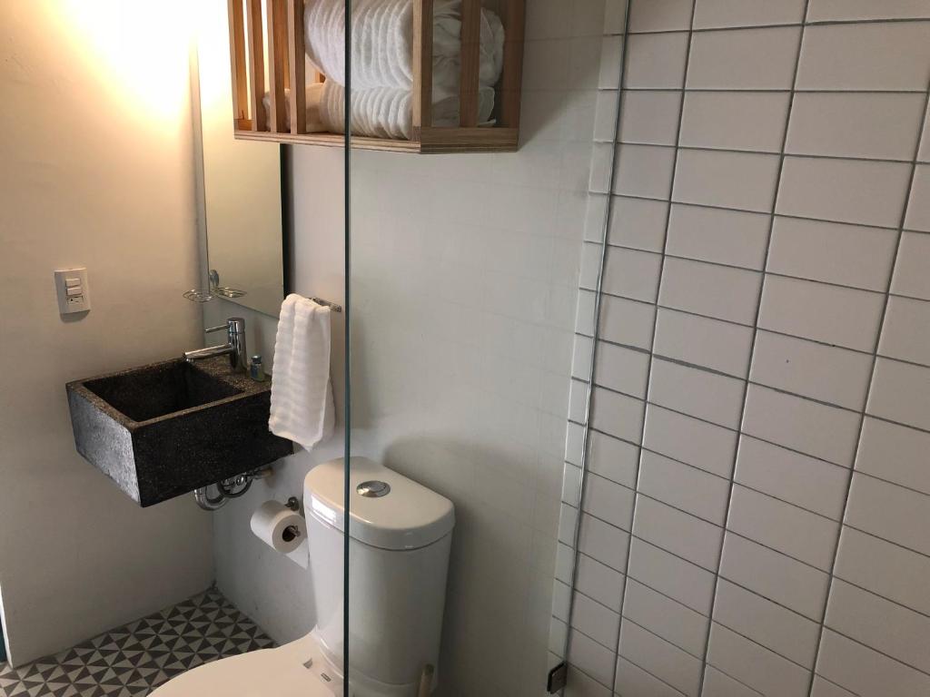 La petite salle de bains est pourvue de toilettes et d'un lavabo. dans l'établissement Casa Nican by Barrio Mexico, à Guadalajara