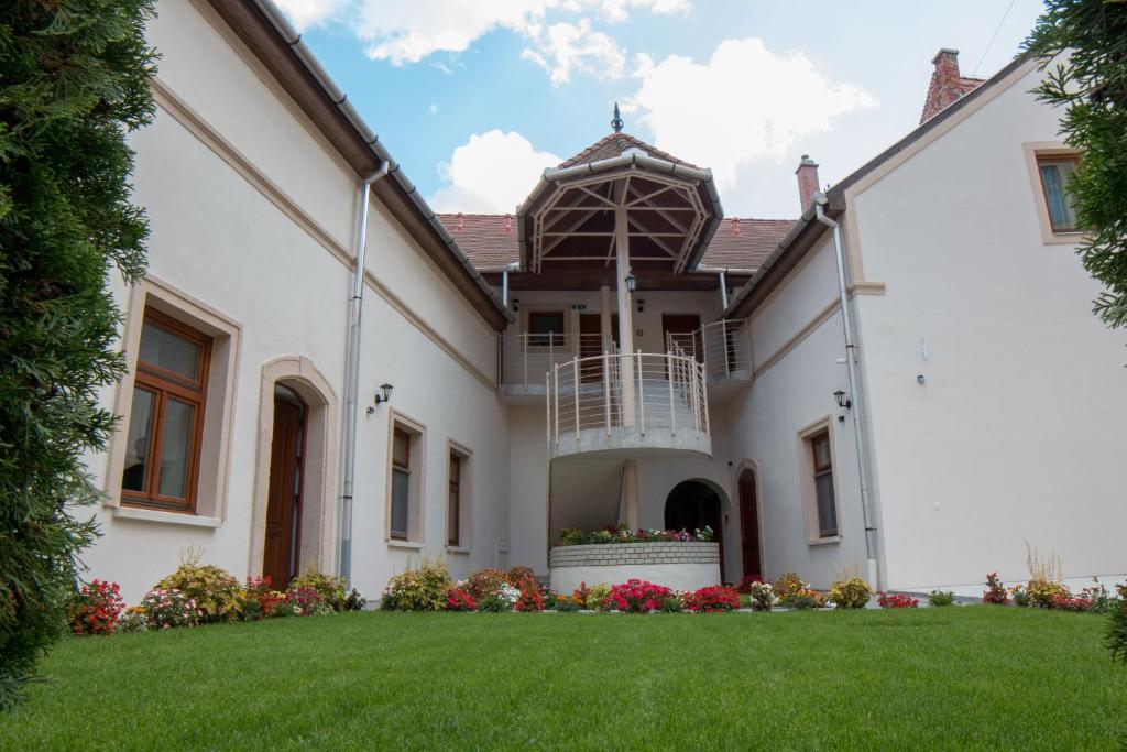 an exterior view of a white house with a yard at Mecset Apartman in Eger