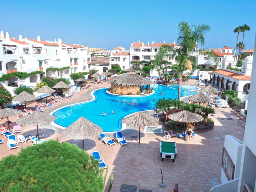 an aerial view of a resort swimming pool with umbrellas at Fairways Club in San Miguel de Abona