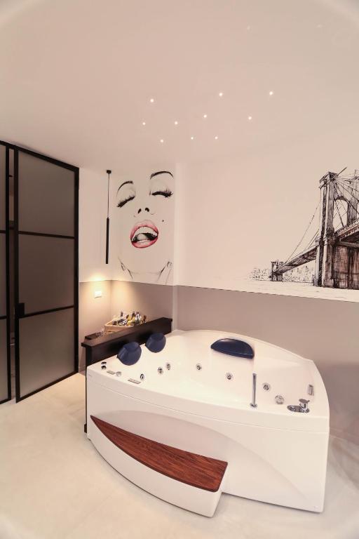 a bathtub in a room with a painting of a woman at O.Effe. Suites / Vatican in Rome
