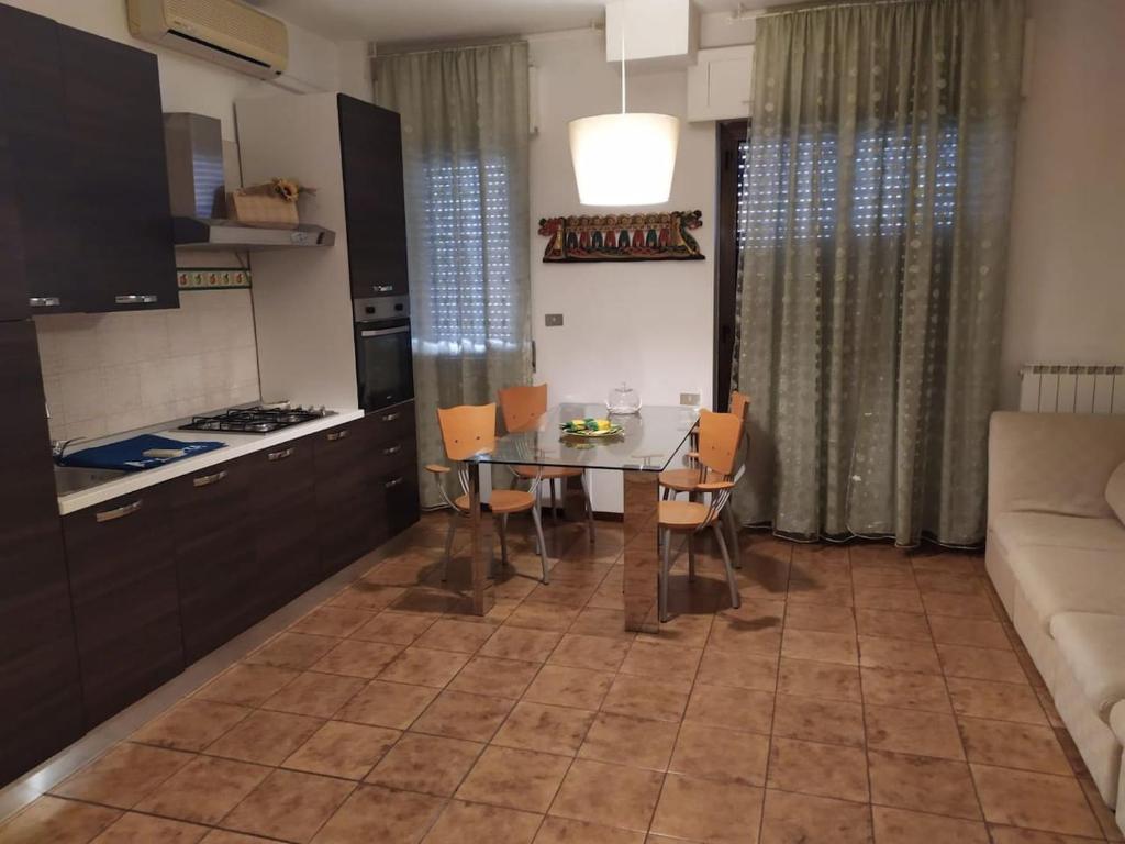 una cucina e una sala da pranzo con tavolo e divano di Casa Trastevere a Foggia