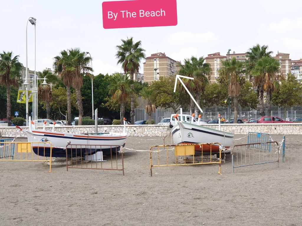 twee boten staan geparkeerd op het zand op het strand bij By The Beach in Málaga