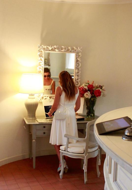 a woman standing at a desk in front of a mirror at Villa Agnese in Sestri Levante