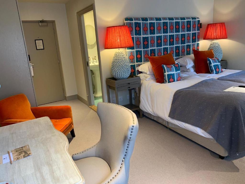 una habitación de hotel con 2 camas y una silla en The Falstaff in Canterbury, en Canterbury