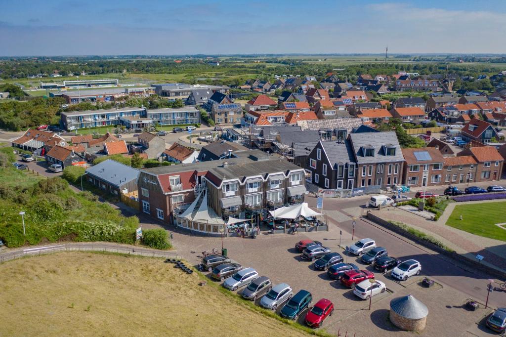 une vue aérienne sur une ville avec des voitures garées dans un parking dans l'établissement Strandhotel Zoutelande, à Zoutelande