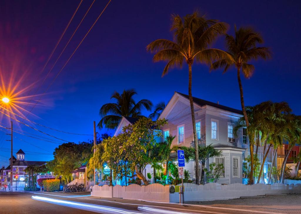 a house with palm trees and a street at night at Duval Inn - Key West in Key West