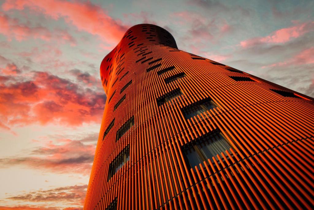 un edificio alto con una puesta de sol en el fondo en Hotel Porta Fira 4* Sup en Hospitalet de Llobregat