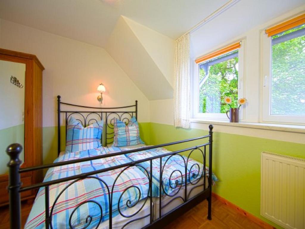 Ferienhof Schwien في مالينتي: غرفة نوم بسرير والجدران زرقاء وأخضر