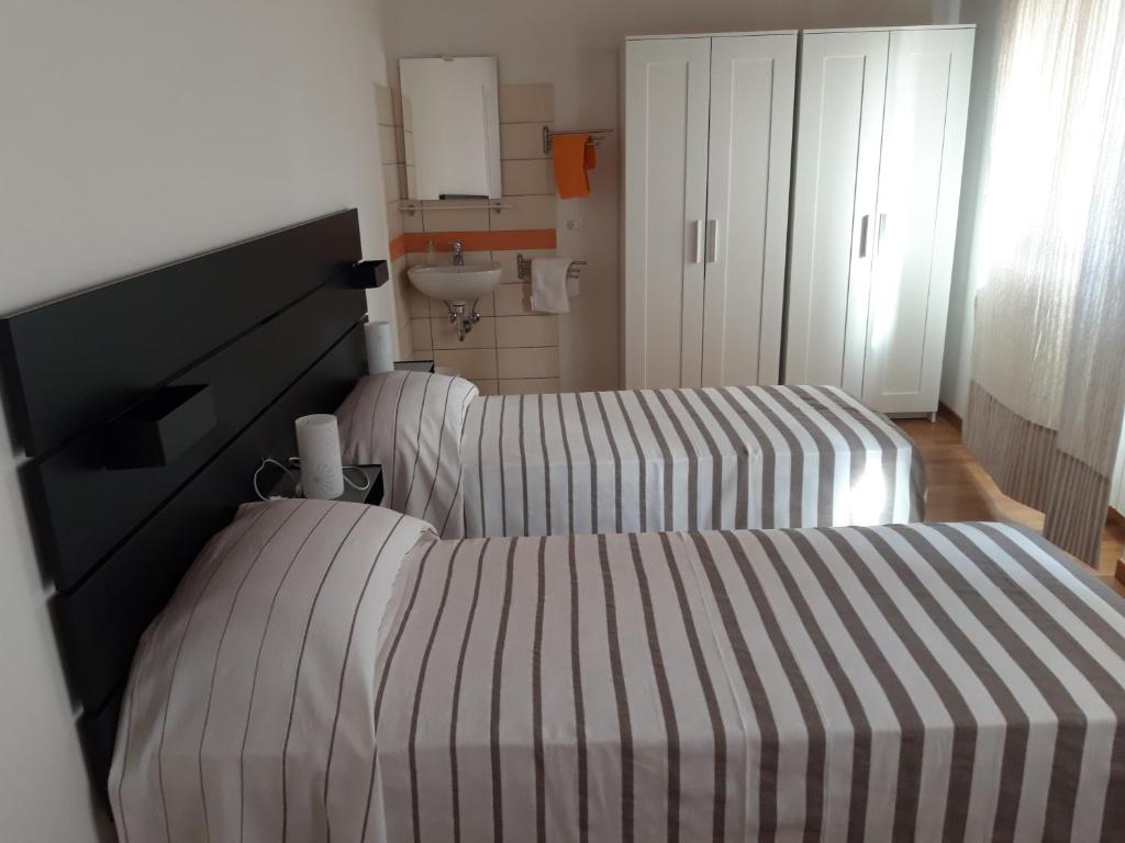 1 dormitorio con 2 camas y lavamanos en al 106, en Trieste
