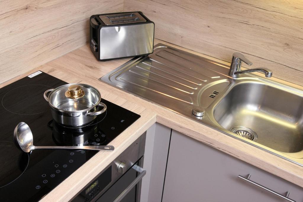 a kitchen counter with a sink and a stove at Wildbachhof in Zell am See