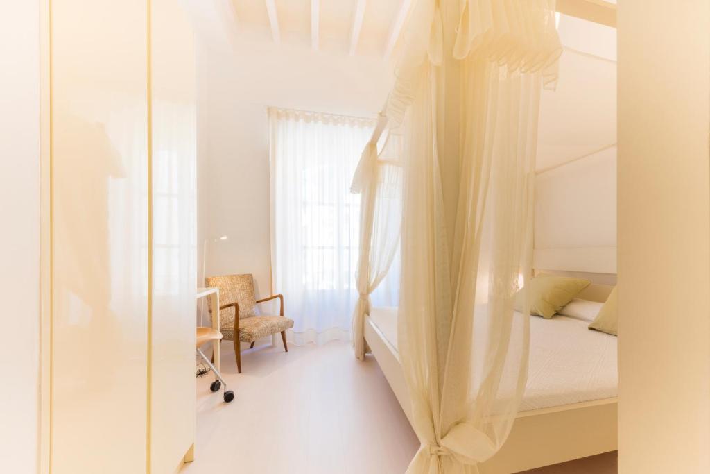 a bedroom with a bed and a desk and a window at Fonda Llabres Boutique in Alcudia