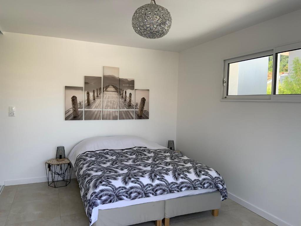 a bedroom with a bed and a picture of a bridge at Chambre privée avec terrasse in Capbreton