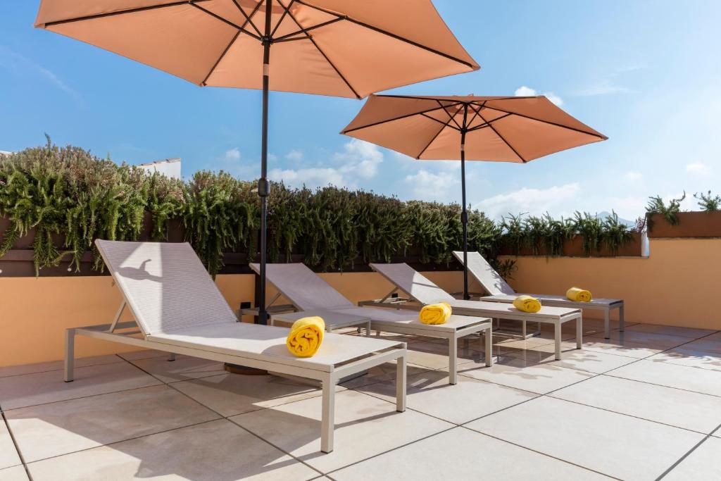 a row of chairs and umbrellas on a patio at Fonda Llabres Boutique in Alcudia