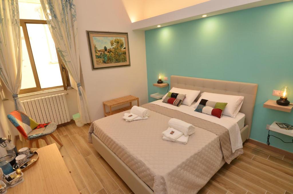 een slaapkamer met een groot bed en handdoeken bij B&B CasaZeni in Napels