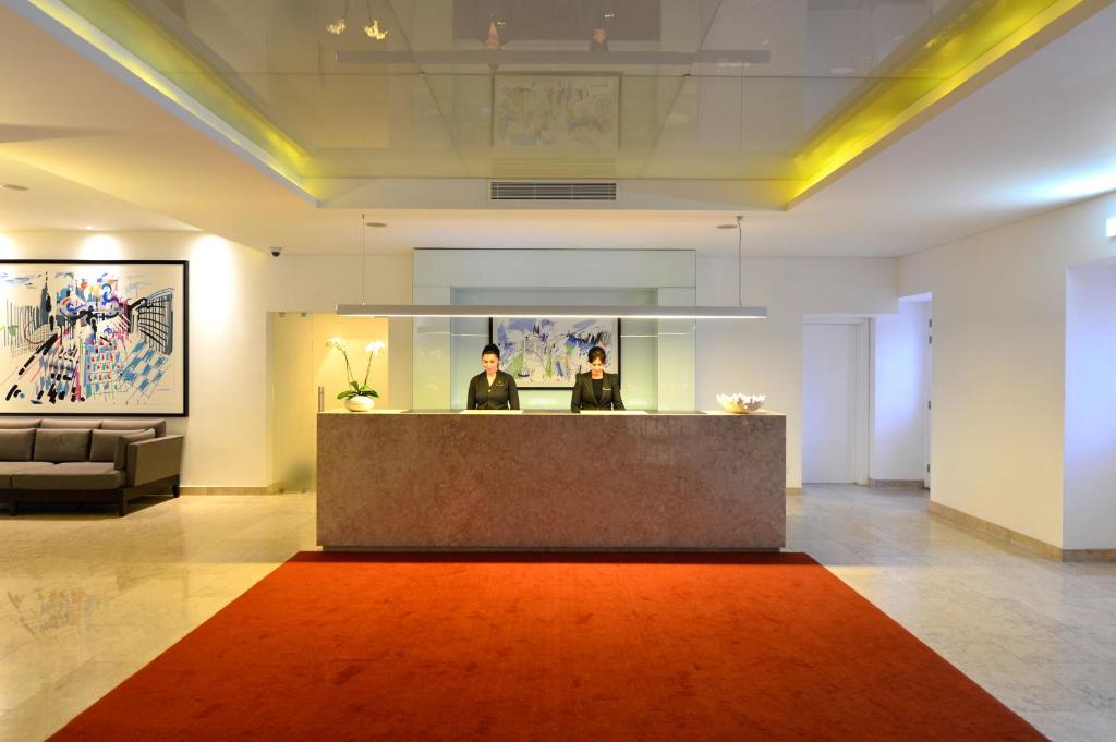 a lobby with a reception desk and a red rug at Pestana Cidadela Cascais - Pousada & Art District in Cascais