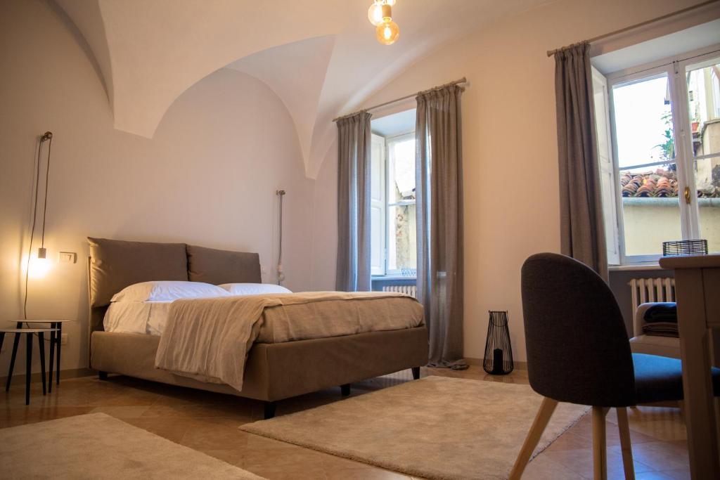 a bedroom with a bed and two windows at R&B Il Viavai in Mondovì