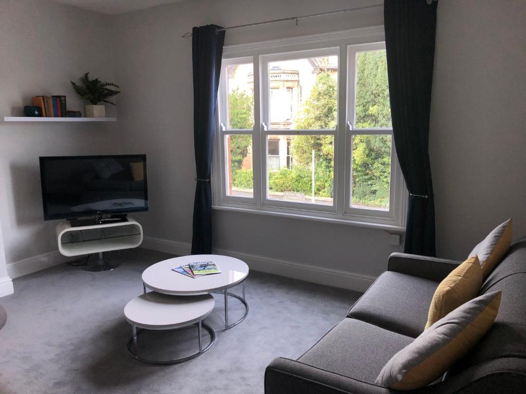 a living room with a couch and a table and a tv at The Croft in Oakham