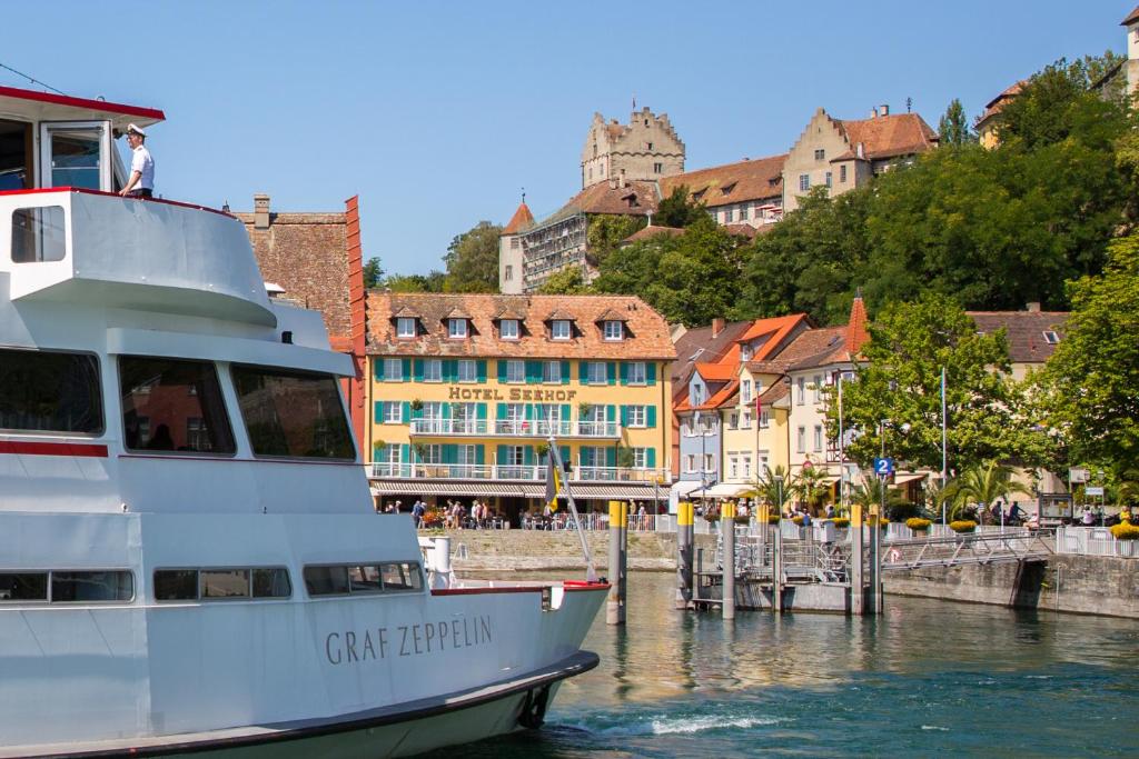 ein Kreuzfahrtschiff, das in einem Hafen mit Gebäuden angedockt ist in der Unterkunft Hotel & Gästehaus Seehof in Meersburg