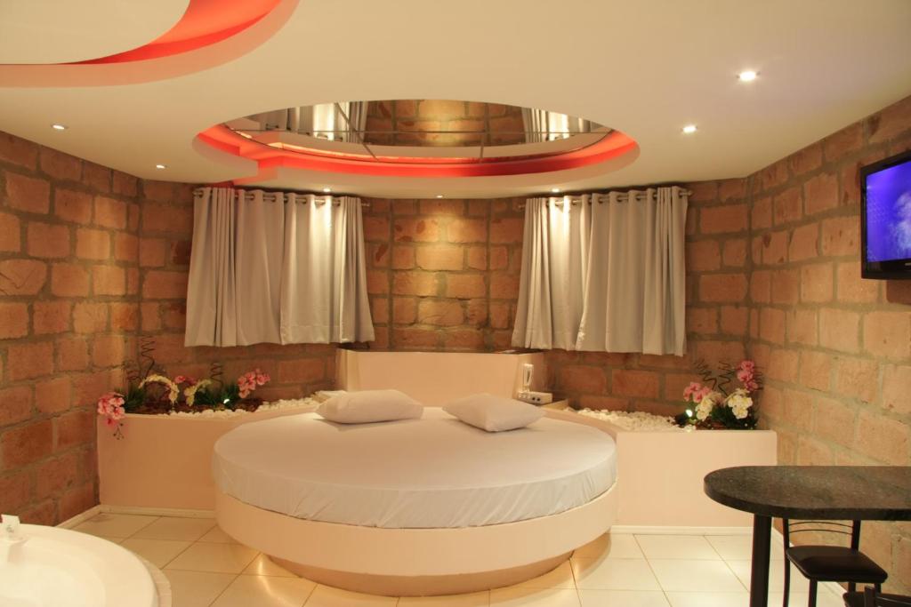 ein Schlafzimmer mit einem runden Bett und einem TV in der Unterkunft Motel Paradiso Panambi in Tabapira