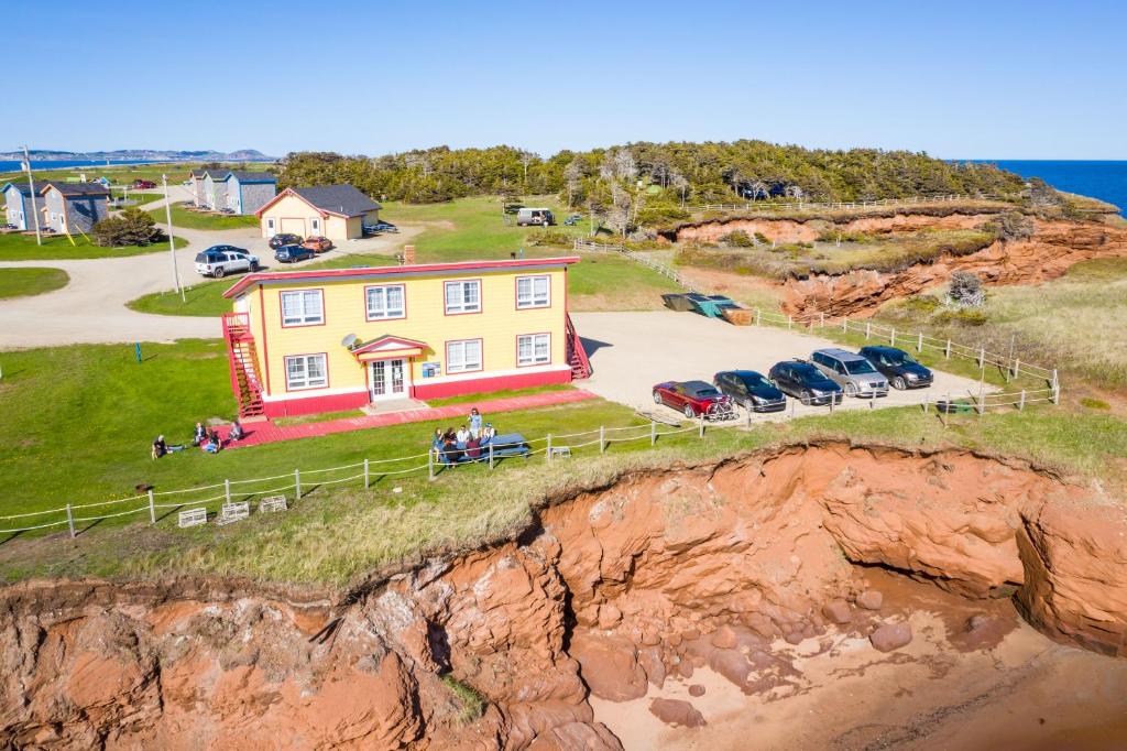an aerial view of a house on a cliff at Auberge de Gros-Cap in Cap-aux-Meules