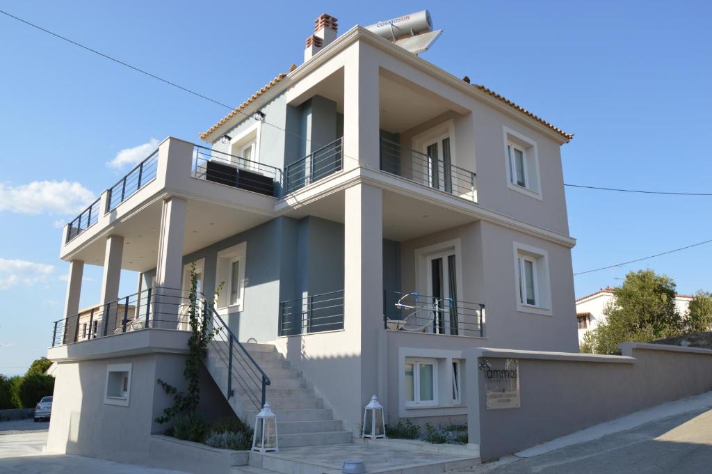 a large white building with stairs in front of it at Ammos Luxury Suites in Elia Laconias