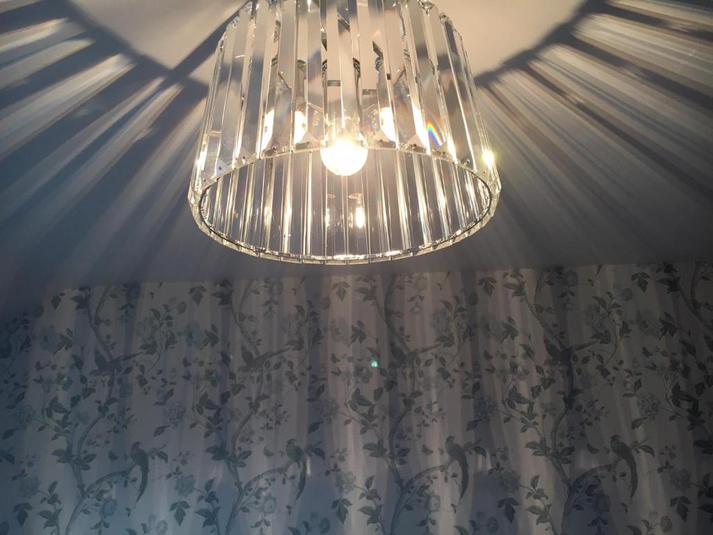 a chandelier hanging from a ceiling with a shower curtain at The Carrick in Portrush