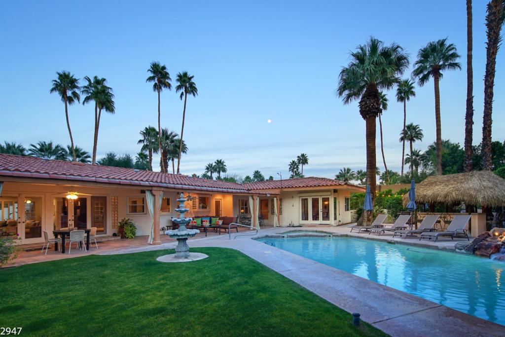 a house with a swimming pool and palm trees at Maison du Soleil in Palm Springs