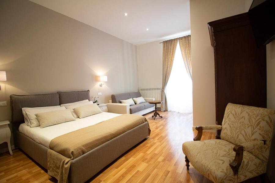 una camera con letto, divano e sedia di Maison Amelie a Trieste