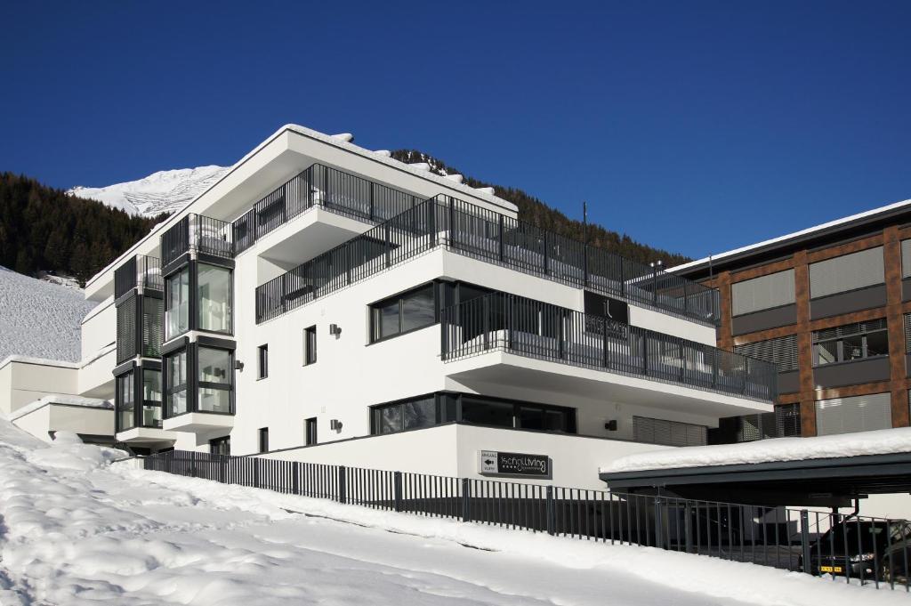 a white building with snow in front of it at Ischglliving Appartements in Ischgl