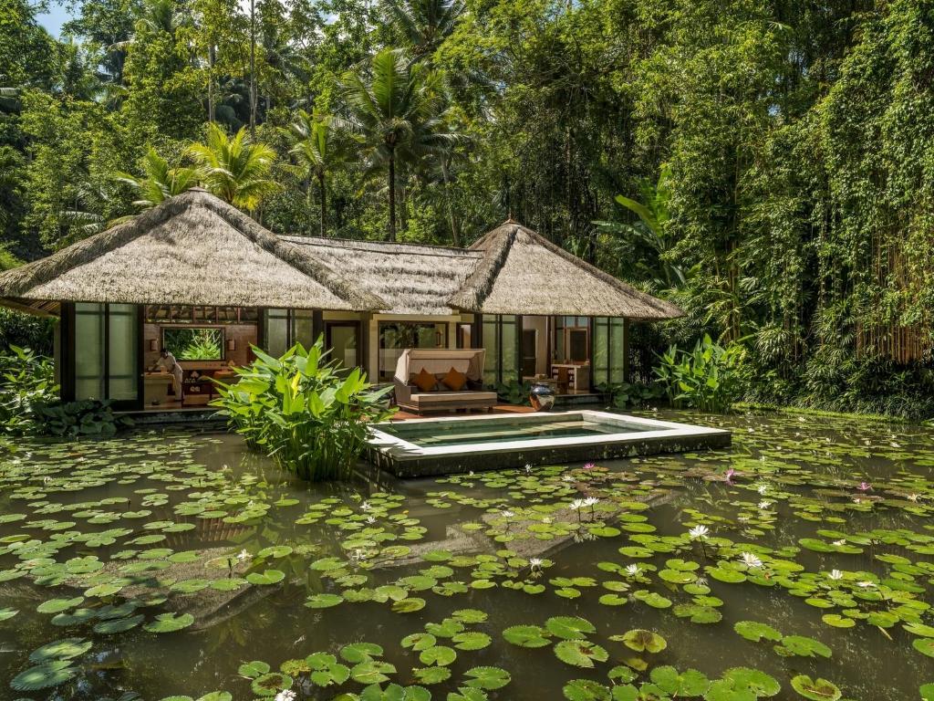 a house in the middle of a pond with lilies at Four Seasons Resort Bali at Sayan in Ubud