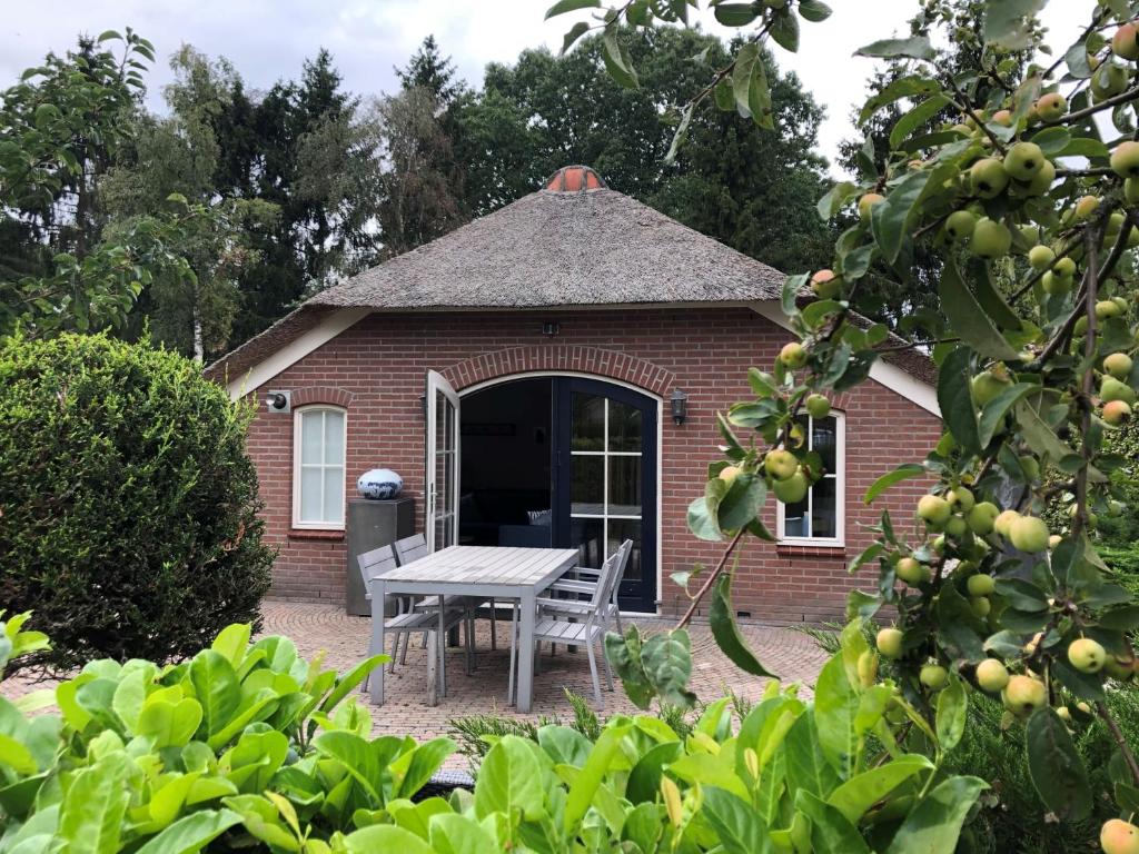 un edificio de ladrillo con una mesa de picnic en el patio en Villa Felix with sauna in Ermelo, en Ermelo