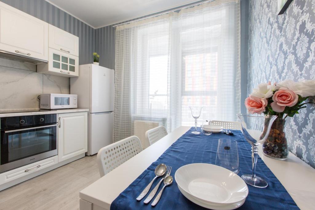 烏法的住宿－SutkiUfa Рудольфа Нуреева 1，厨房配有一张桌子,上面有蓝色的桌布