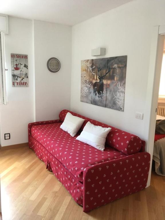 un soggiorno con divano rosso e 2 cuscini di Appartamento Alla Fonte a Madesimo